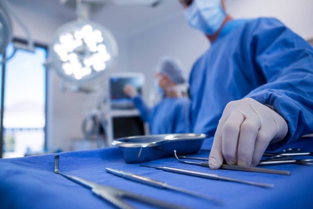 Surgeon holding surgical tool in operation theater.