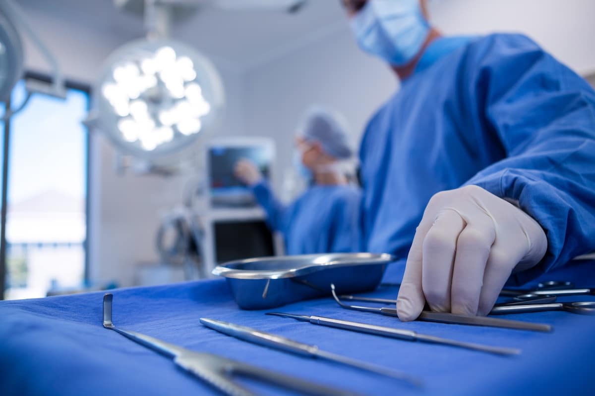Surgeon holding surgical tool in operation theater.