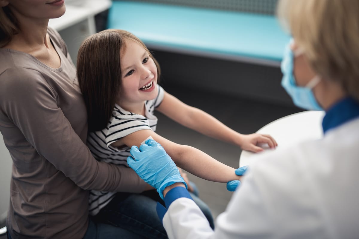 A little girl having her arm prepped for an immunization at Healthy Connections.