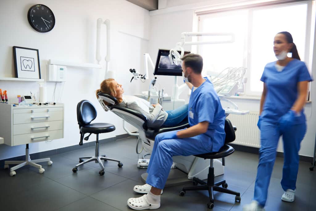 A patient laying in a dentist chair, receiving dental care from a Healthy Connections provider.