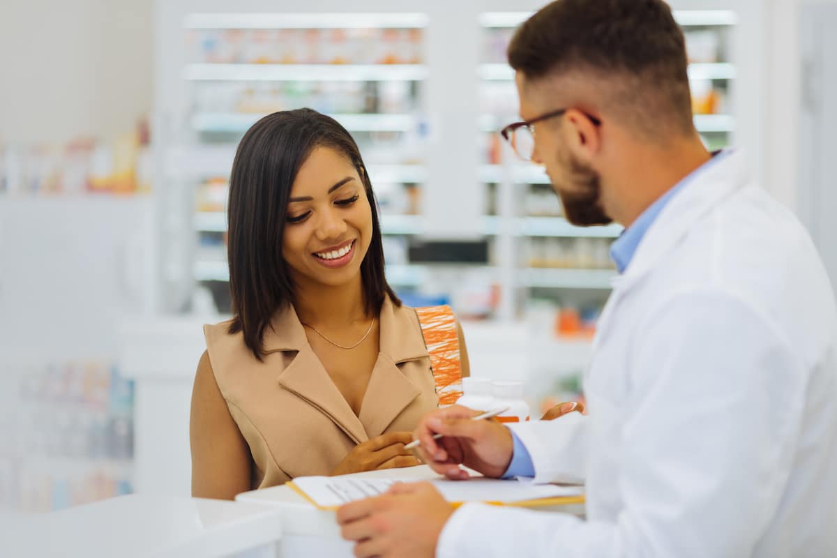 A woman picking up her prescription from Healthy Connections pharmacy.