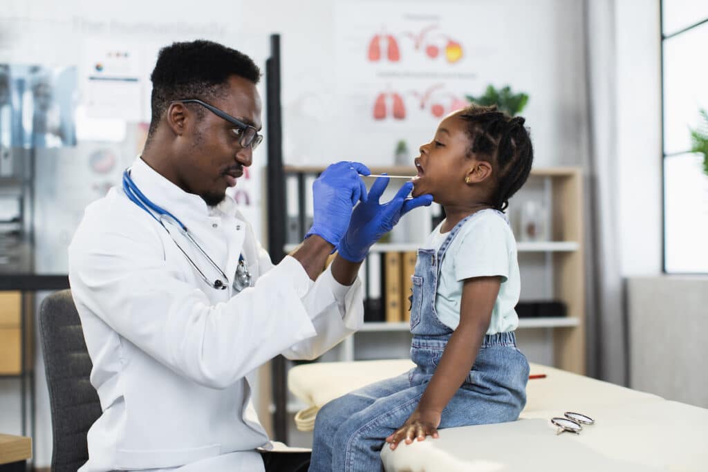 A doctor providing medical services to a young girl on an examination table.