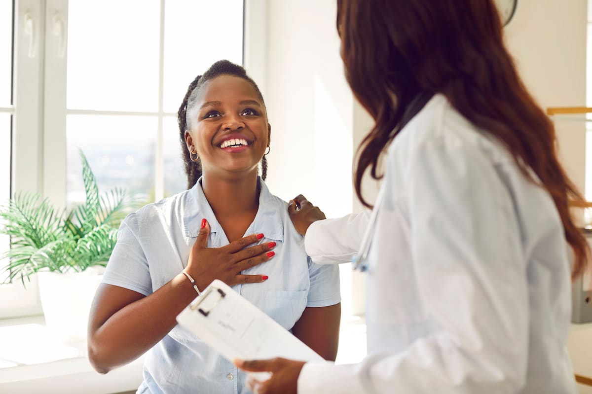 A doctor comforting a patient as she receives relieving news.