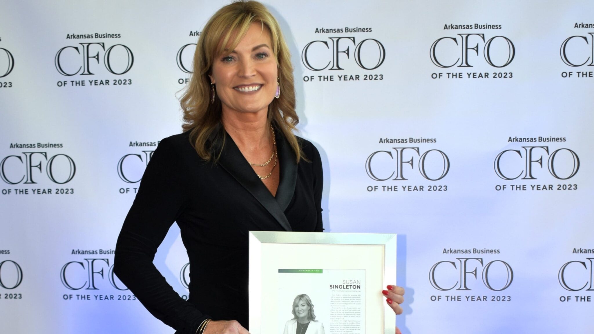 The CFO of Healthy Connections, Susan Singleton, poses with an award at the Arkansas Business of the Year 2023.