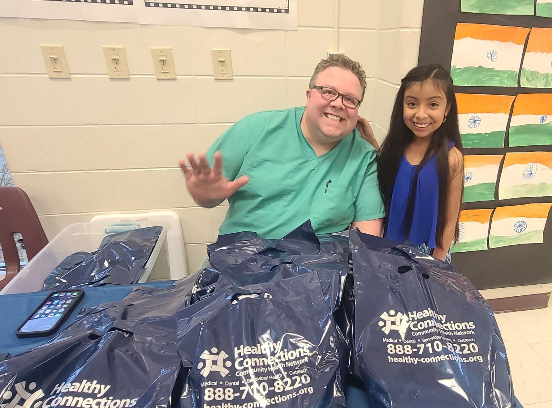 Dr. Jeremy Porter of My Kids Pediatric Clinic in Hot Springs poses with a little girl at a table during Lake Hamilton ESOL Family Night.