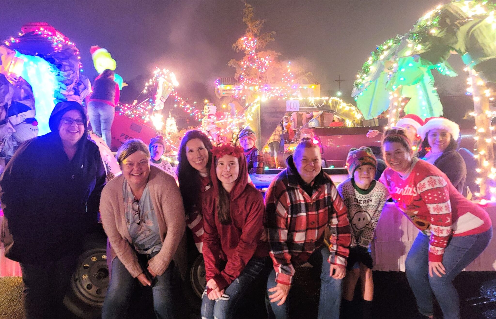 The Healthy Connections Mena staff posing a the Christmas parade in front of their float.