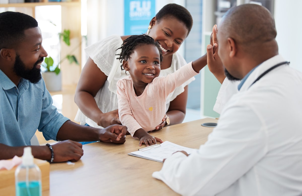 A little girl reaching out to high five her care provider. Contact Healthy Connections for an appointment.