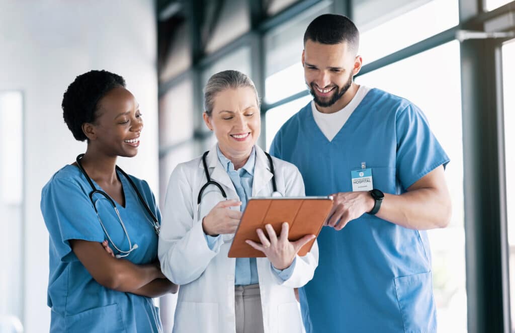A doctor talking with two nurses in a hallway.