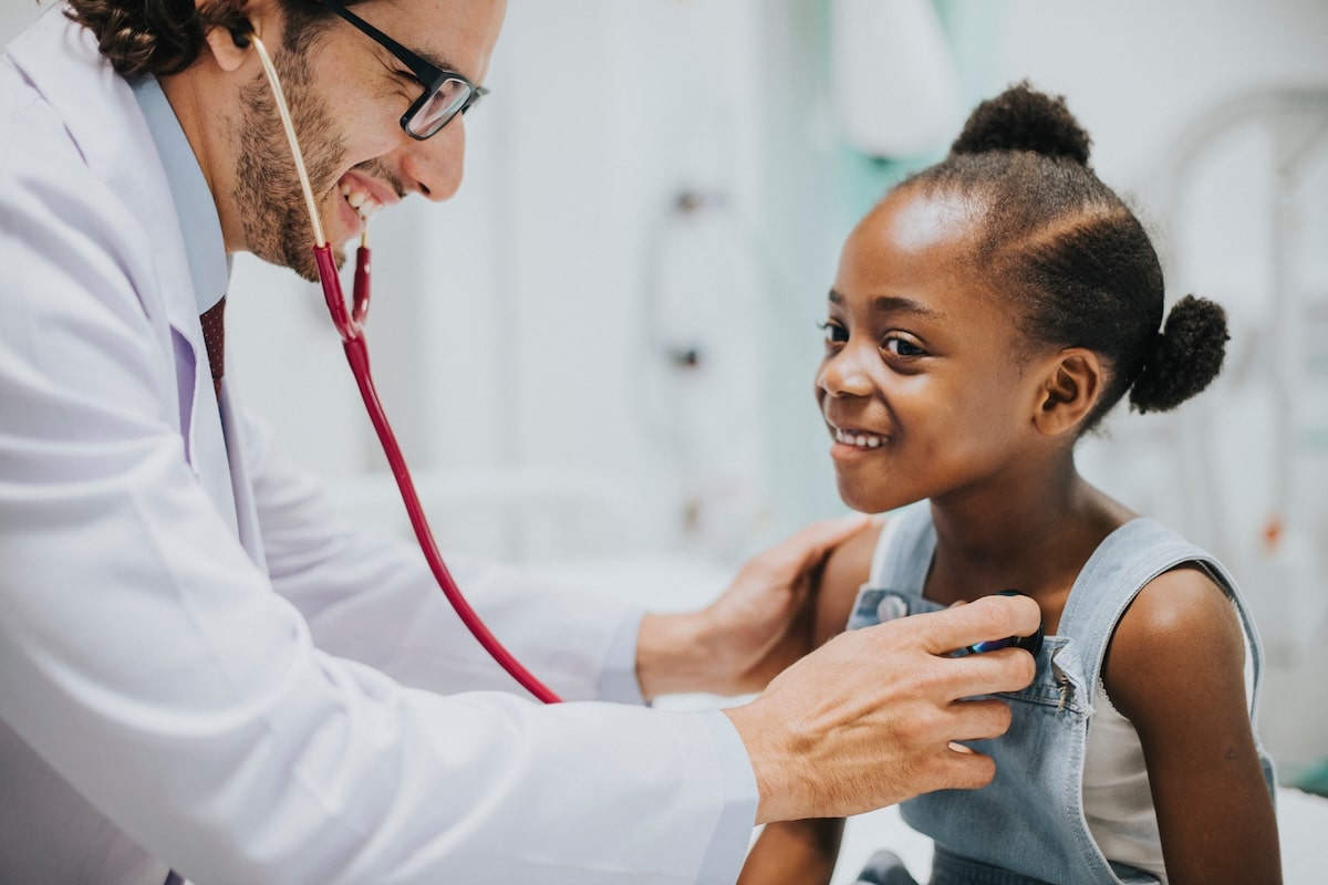 A doctor performing a checkup on a child in the ARKids First program.