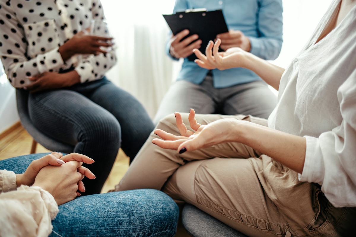 Women sitting in a counselor office, talking with each other in a group setting at Healthy Connections.