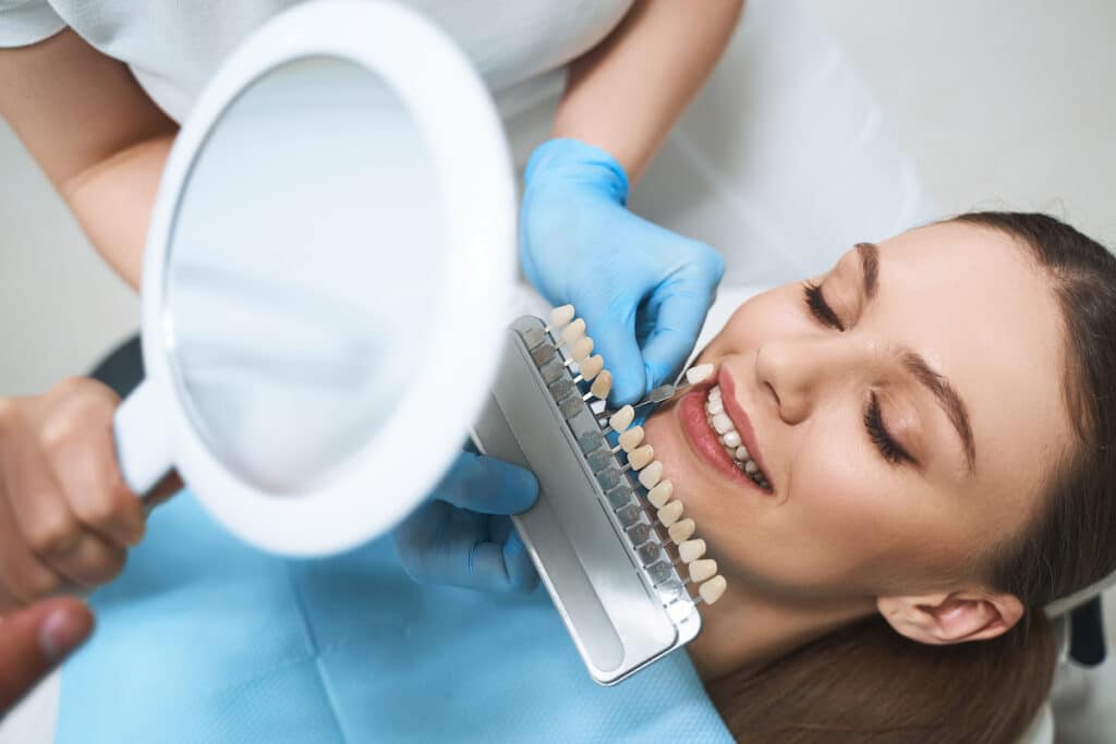 A young woman is visiting her dentist cosmetic dentistry to improve her smile with specialist help.