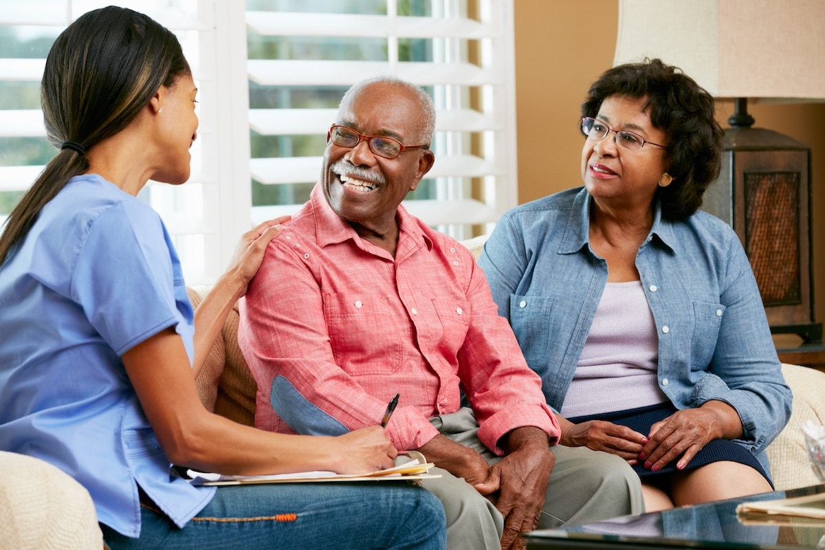 A nurse talking to a senior couple after an examination at a PCMH.
