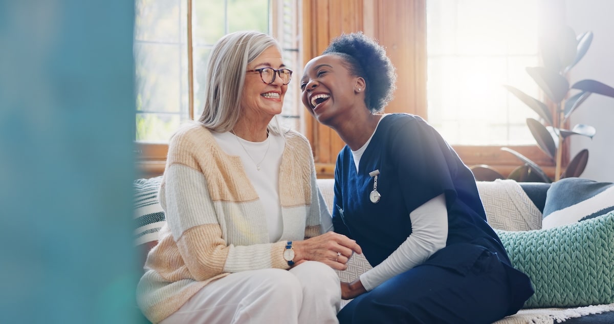 Senior patient, laughing and talking with her nurse at a Patient-Centered Medical Home.