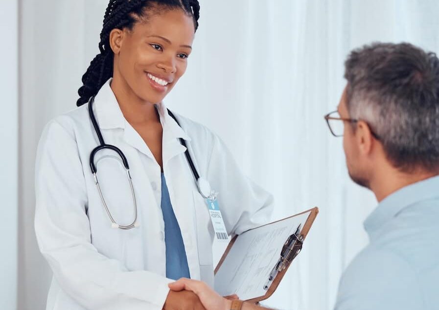 A doctor shaking hands with a new patient.